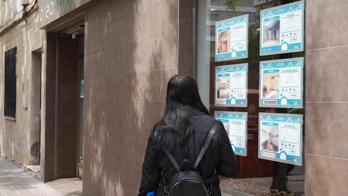 Una persona observa el escaparate de una inmobiliaria en Castellón.