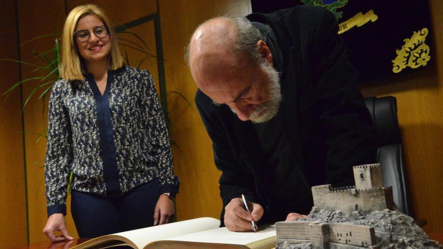 Raúl Zurita firmando ante la alcaldesa Irene Navarro