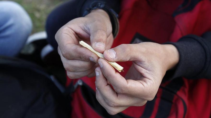 Un hombre lía un porro.