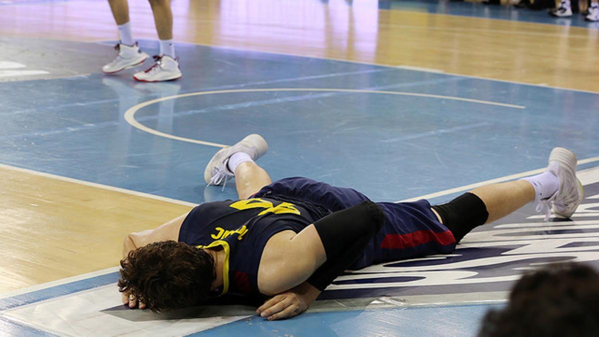 Tomic, tumbado en el parquet del Palau, en un momento del tercer y definitivo partido de la final de la Liga Endesa entre el Barça y el Madrid