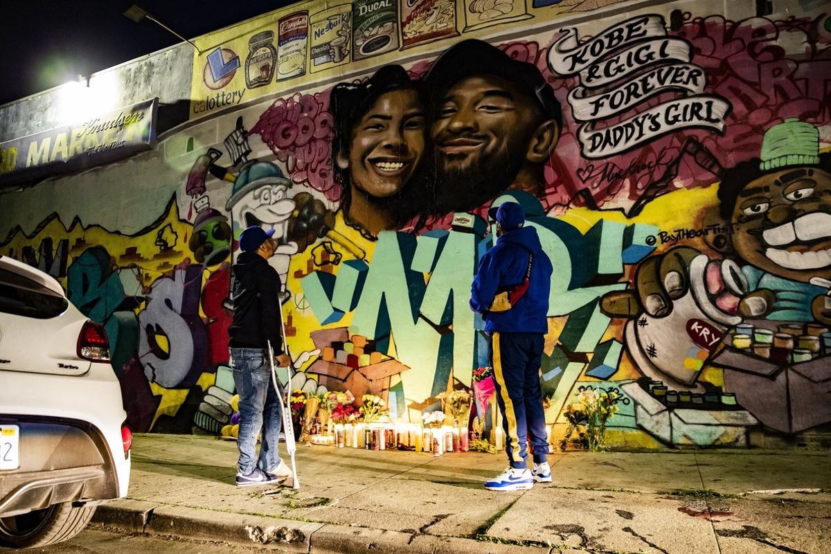 Los Angeles (United States), 28/01/2020.- Fans pay their respect at a makeshift memorial in front of a mural by the artists Mr79lts and Muck Rock showing Kobe Bryant and his daughter Gianna Bryant on a wall of the Pickford Market in Los Angeles, California, USA, 27 January 2020. Former US basketball player Kobe Bryant, his daughter Gianna, and seven others have died in a helicopter crash in Calabasas, California, USA on 26 January 2020. He was 41. (Baloncesto, Estados Unidos) EFE/EPA/ETIENNE LAURENT