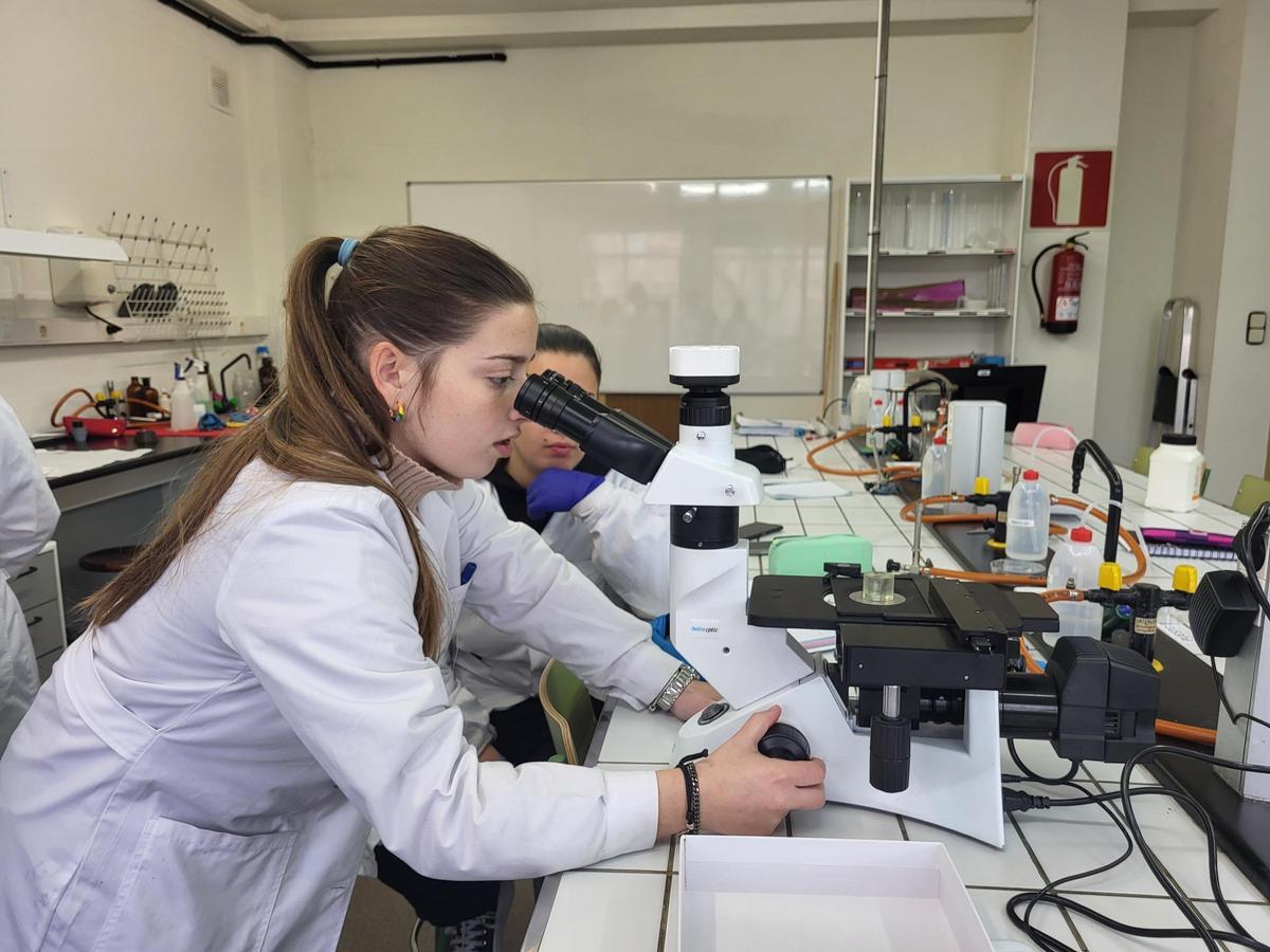 Una alumna emplea el microscopio metalográfico.