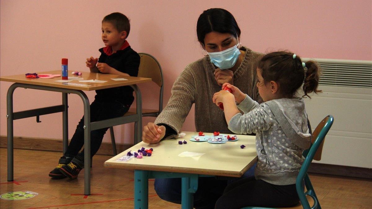 Una profesora junto a una alumna en una escuela.