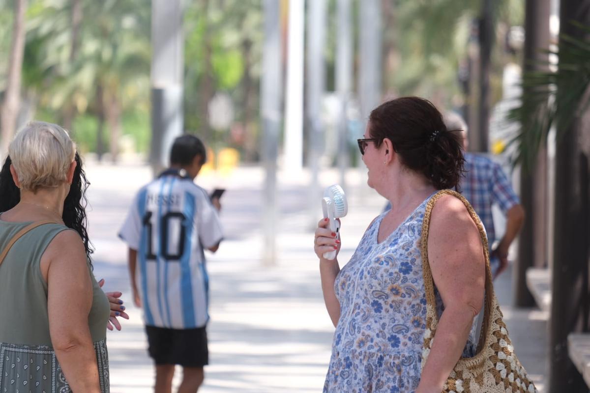 Refrescándose con un ventilador portátil.