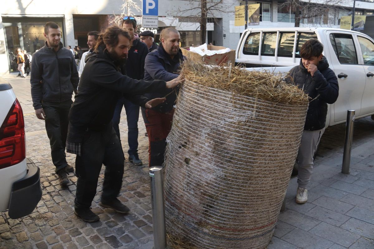Revolta Pagesa descarrega una bala de palla davant de la Delegació del Govern a Girona.