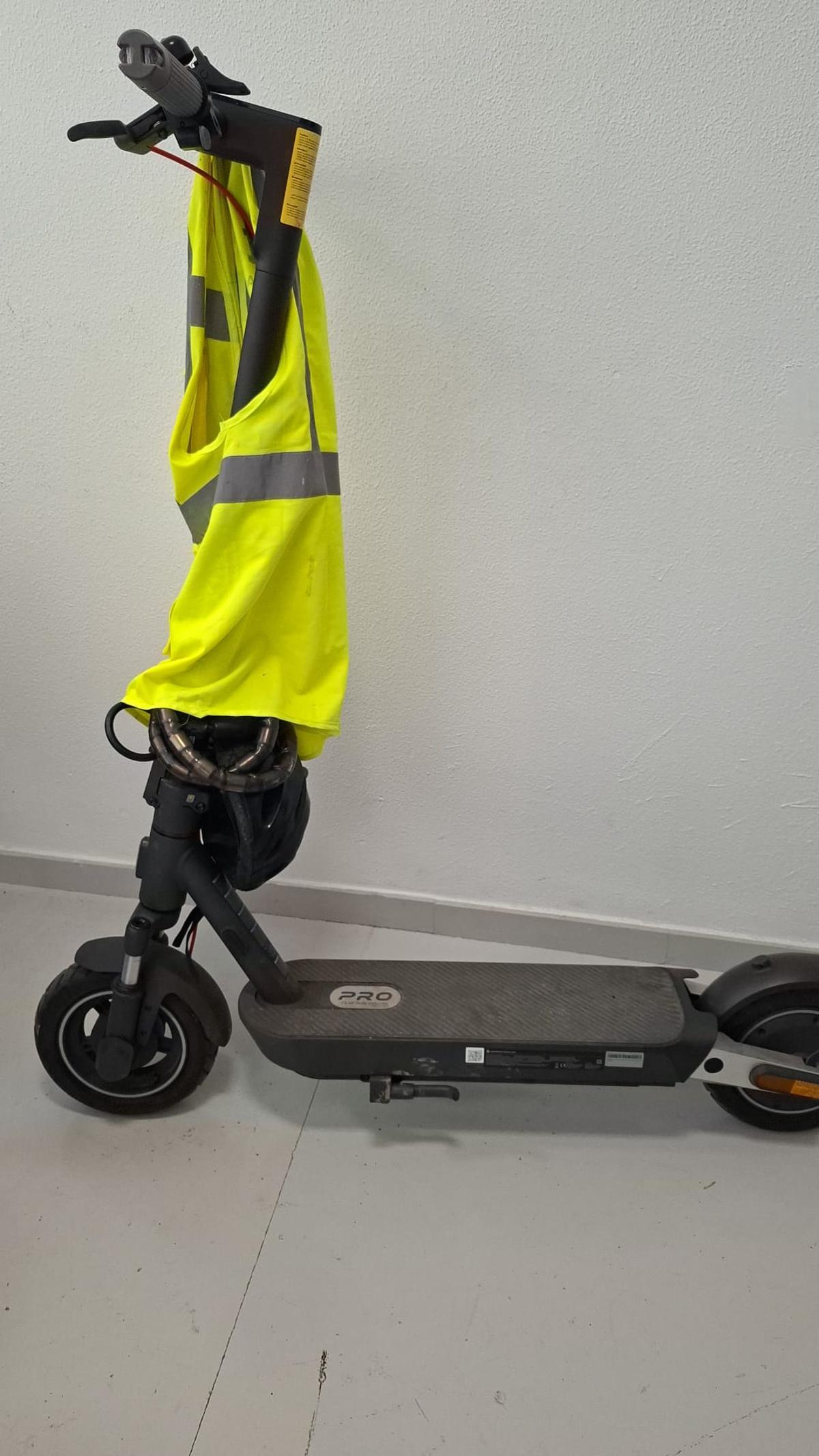 El patinete en el que circulaba el fallecido, con el casco y el chaleco enganchados al manillar.