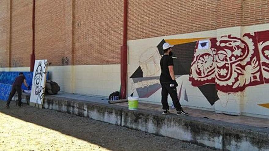 Participantes crean sus obras con spray durante los talleres de graffiti y arte urbano.