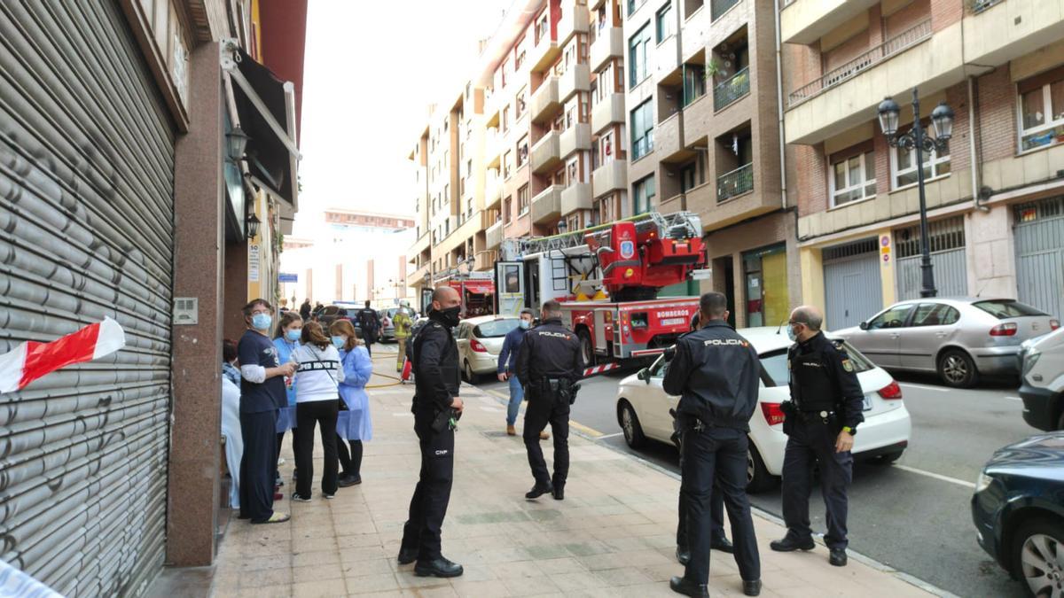 Vecinos siendo atendidos en el exterior del bloque de viviendas.