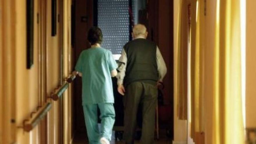 Una trabajadora de una residencia acompañando a una persona mayor. | L. O.