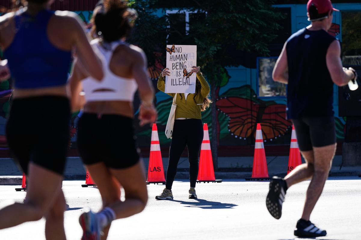 A woman holds a sign as runners participate in the Chicago Marathon, Sunday, Oct. 12, 2025. (AP Photo/Nam Y. Huh)