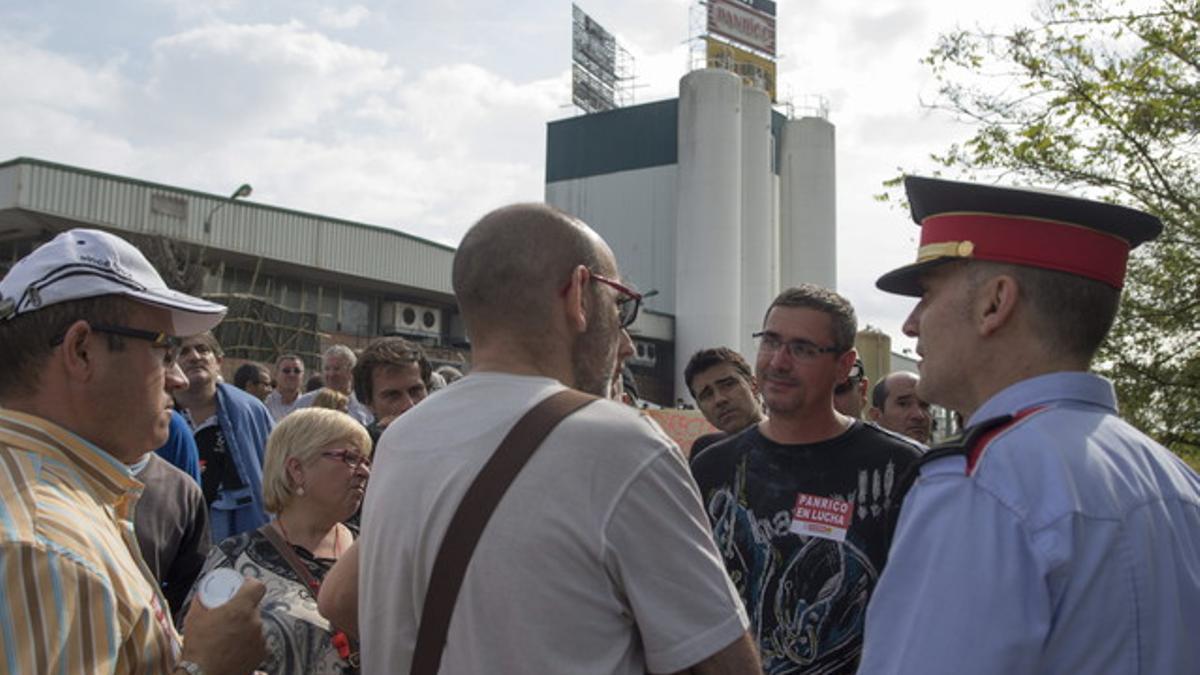 Empleados de Panrico hablan con agentes de los Mossos, ante la fábrica, el jueves.