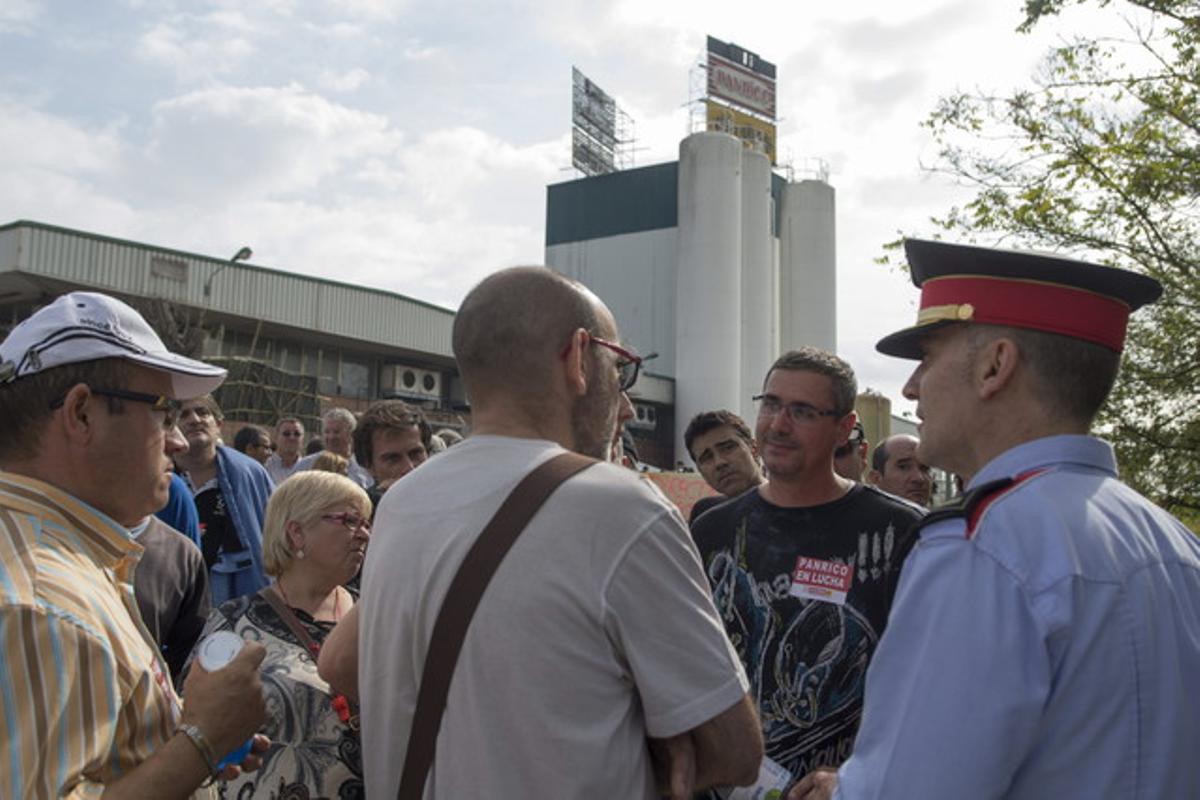 Empleats de Panrico parlen amb agents dels Mossos, davant la fàbrica, dijous. Empleats de Panrico parlen amb agents dels Mossos, davant la fàbrica, dijous.