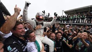 El británico Lewis Hamilton es elevado a los cielos por los mecánicos de Mercedes.