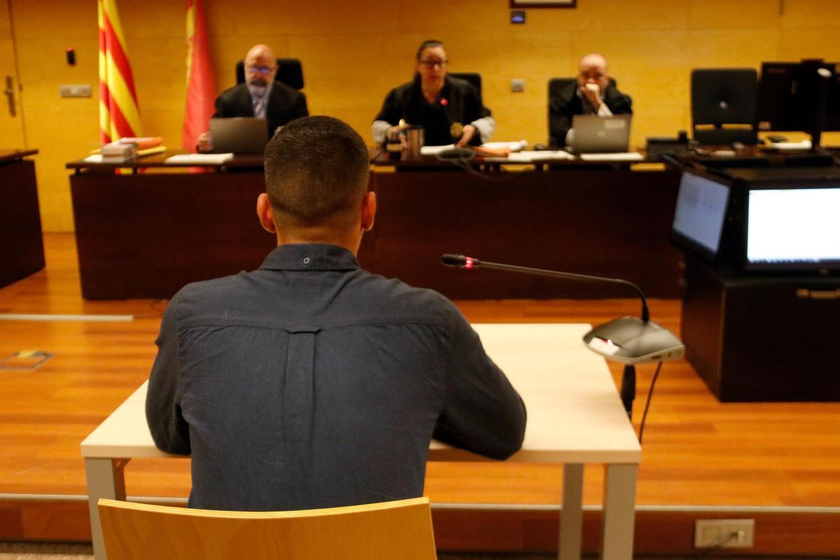 D'esquenes, l'acusat de violar una dona amb discapacitat a Girona. Foto del judici a l'Audiència