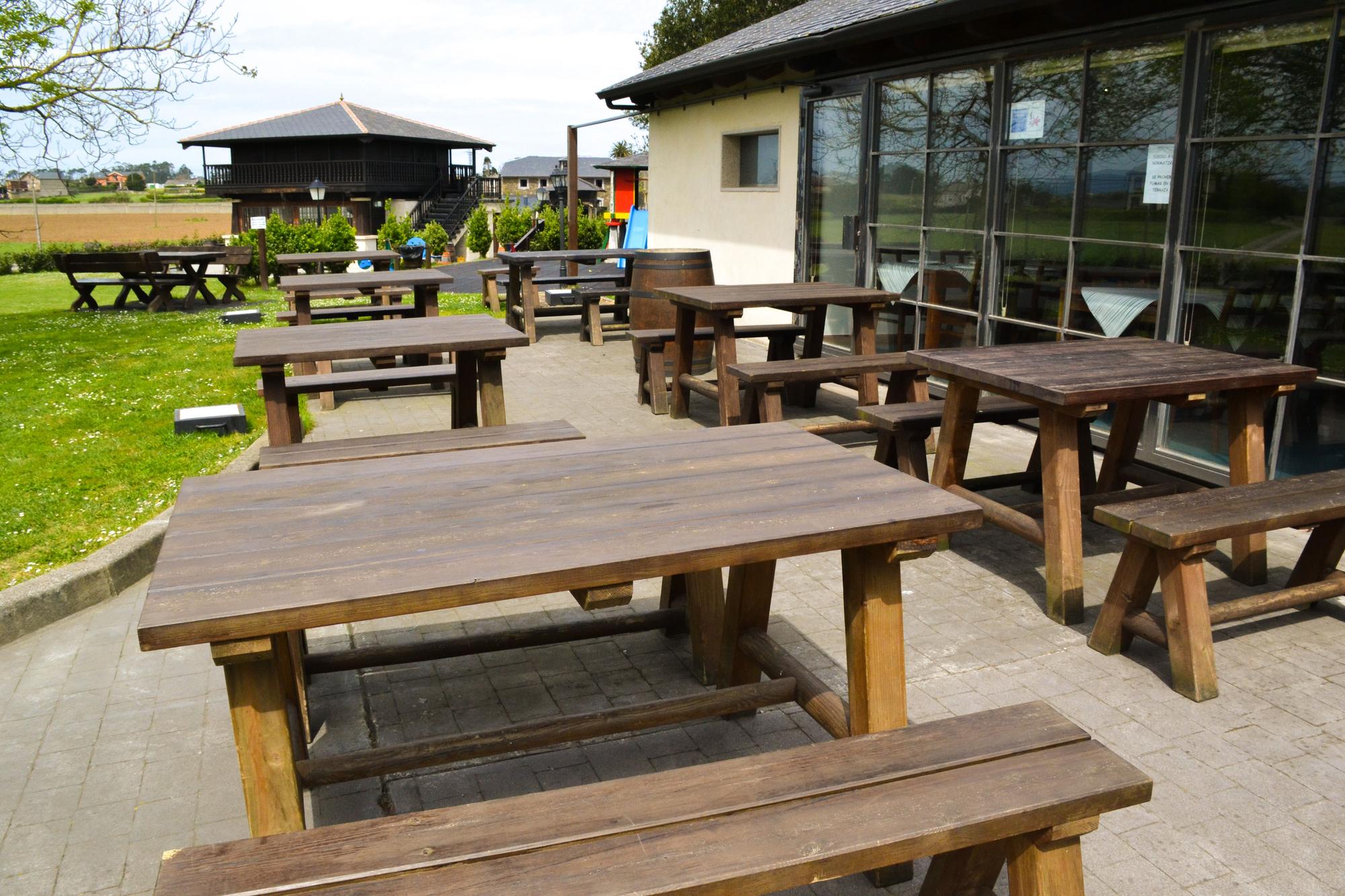 Terraza del local, con el horreo y el parque infantil al fondo.