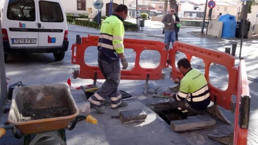 Operarios renuevan uno de los imbornales de la calle Hospital.