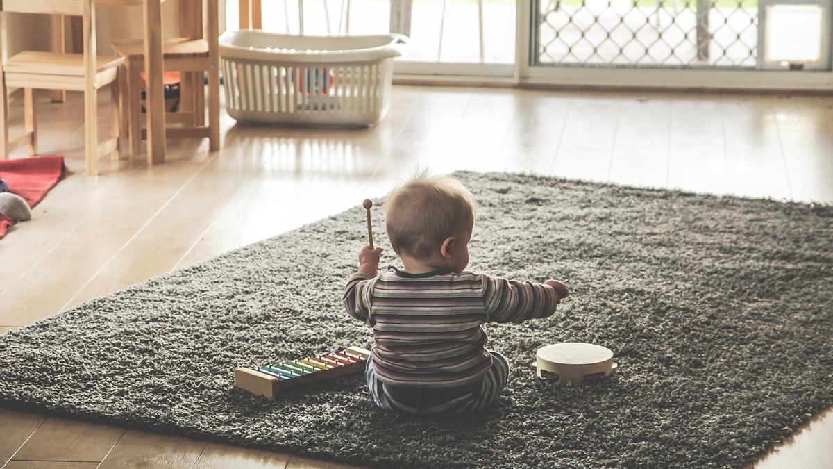 Un bebé juega en la alfombra de su casa