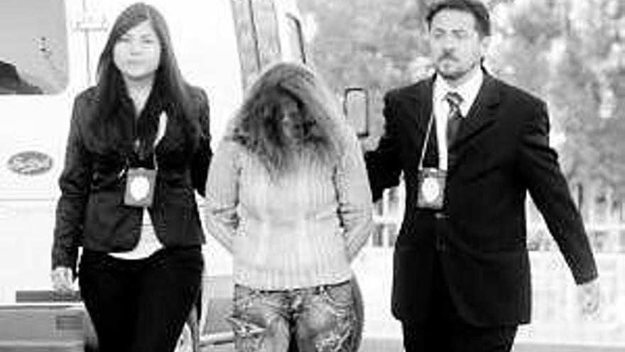 La mujer detenida en Chile, entre dos agentes judiciales.