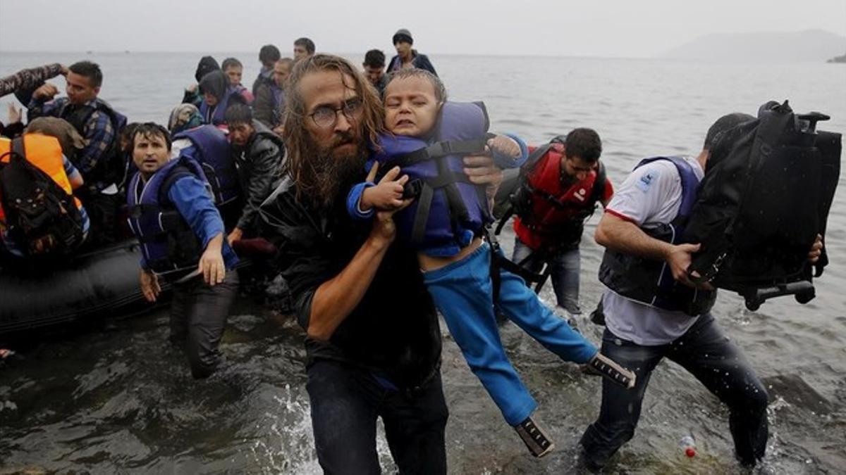 Un voluntario traslada a un inmigrante naufragado al intentar alcanzar la isla griega de Lesbos.
