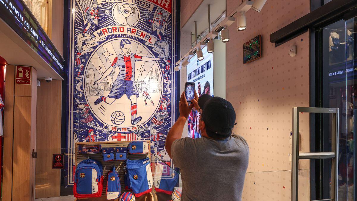 Un aficionado hace una foto al mosaico de la tienda del Barça en Madrid