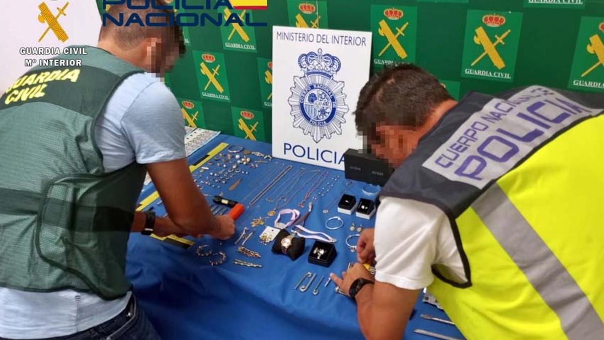 Agentes de la Guardia Civil y la Policía Nacional con las joyas intervenidas.