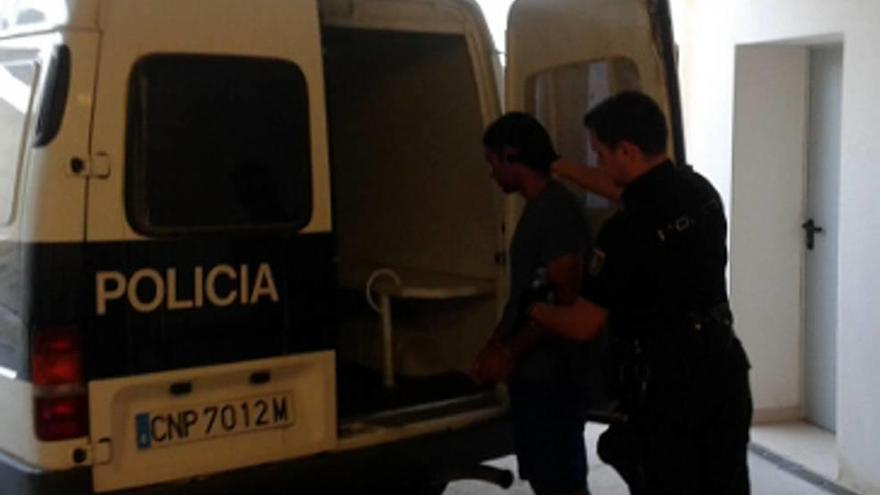 Un policía introduce al maltratador detenido en el furgón.