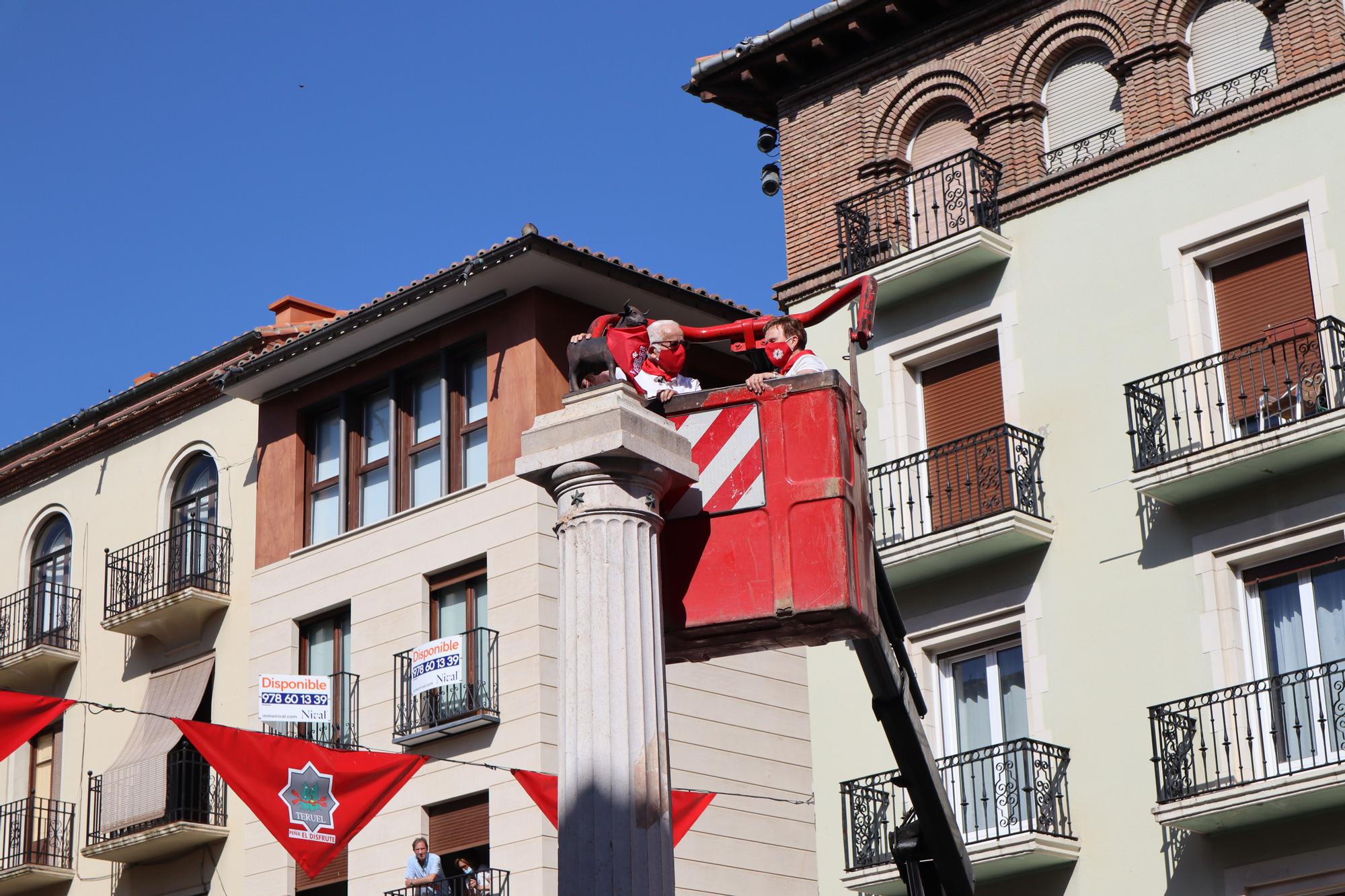 FOTOGALERÍA | La Peña El Agüelo sube en grúa para colocar el pañuelo al Torico de Teruel, en el segundo año sin Fiestas del Ángel