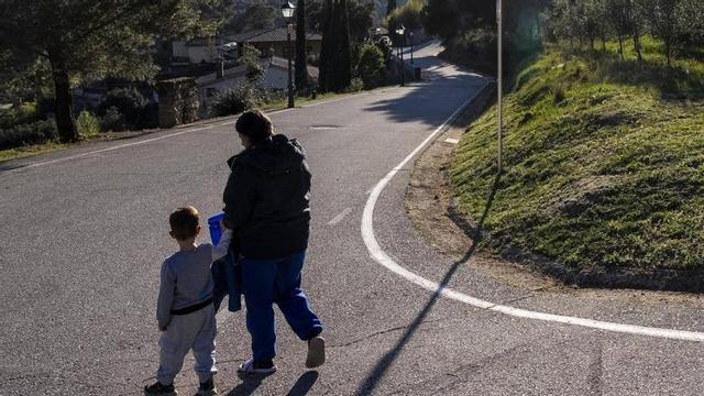Una família torna a casa després de l’arribada del bus escolar, a Gallifa. | FERRAN NADEU