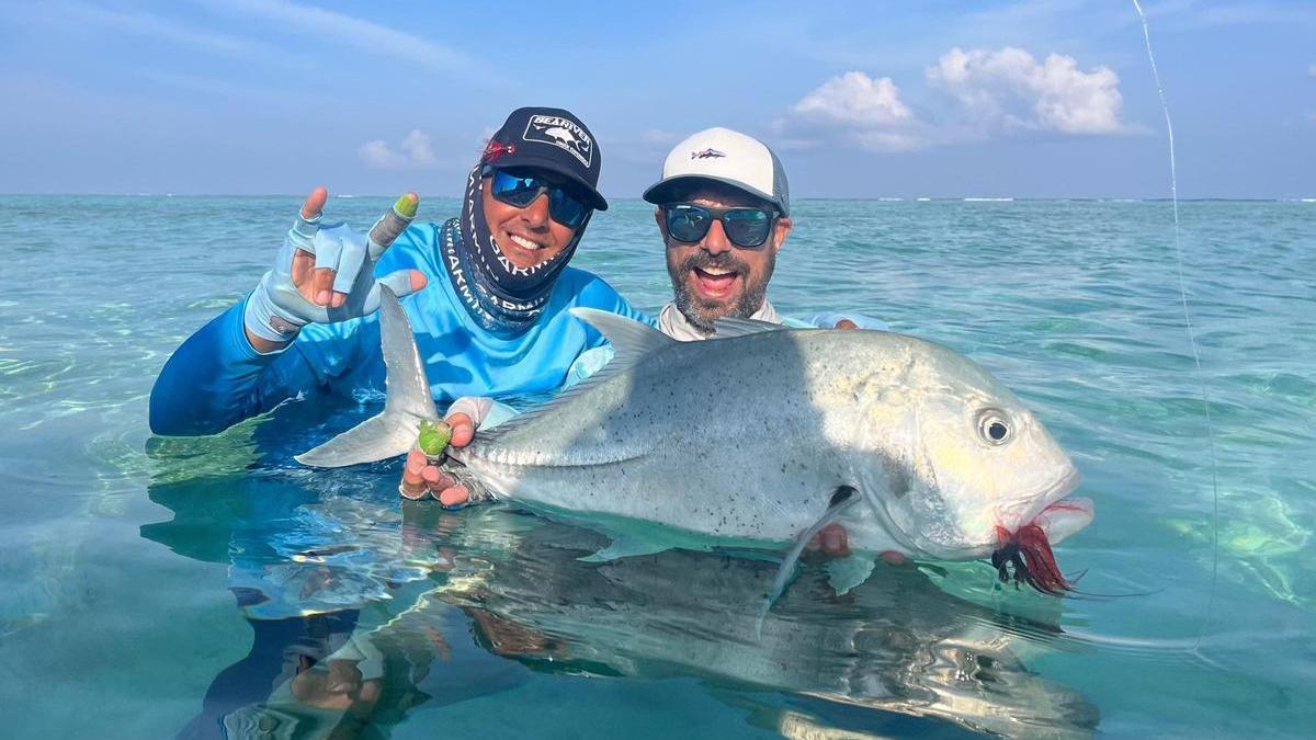 Yadai Bravo, fundador de SeaRiver Fishing Trips, junto a un cliente durante una jornada de pesca, con un jurel.