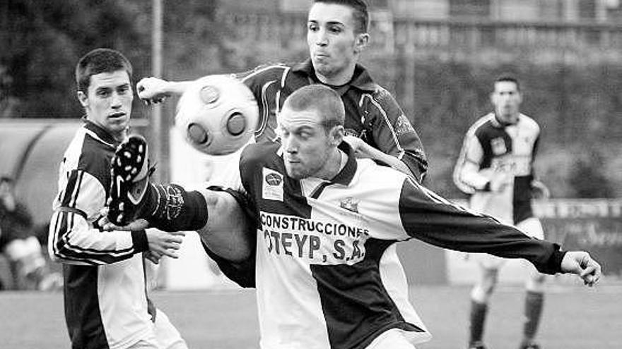 El arlequinado Xabel pugna por llevarse el balón ante el medio del Navarro Israel, con Borja Prieto siguiendo la jugada.