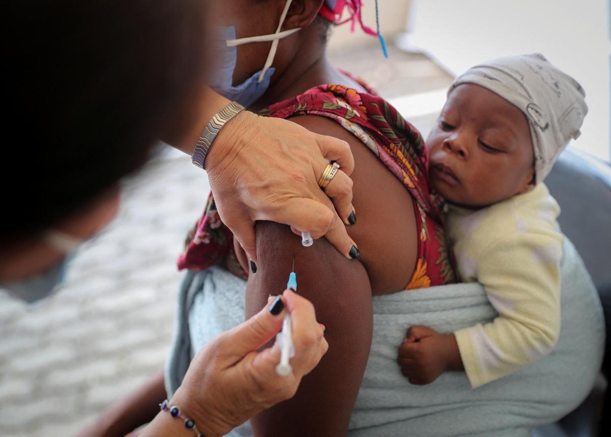 FILE PHOTO: Healthcare worker administers the coronavirus disease (COVID-19) vaccine to a woman, in Johannesburg