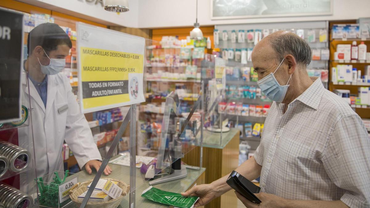 Un hombre con mascarilla en una farmacia