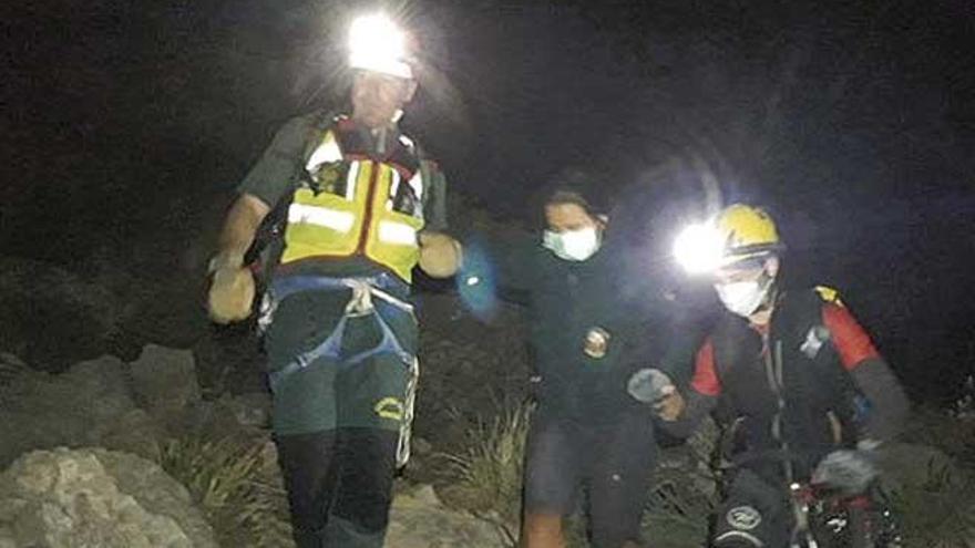 Un guardia civil y un bombero rescatan, ayer, a la mujer en el Cavall Bernat.