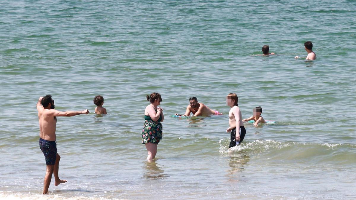 Familias y grupos de amigos intentando bañarse el martes en Samil.