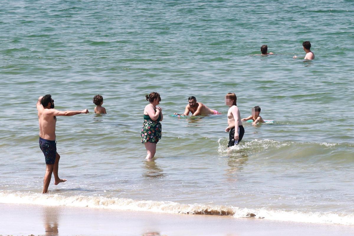 Familias y grupos de amigos intentando bañarse el martes en Samil.