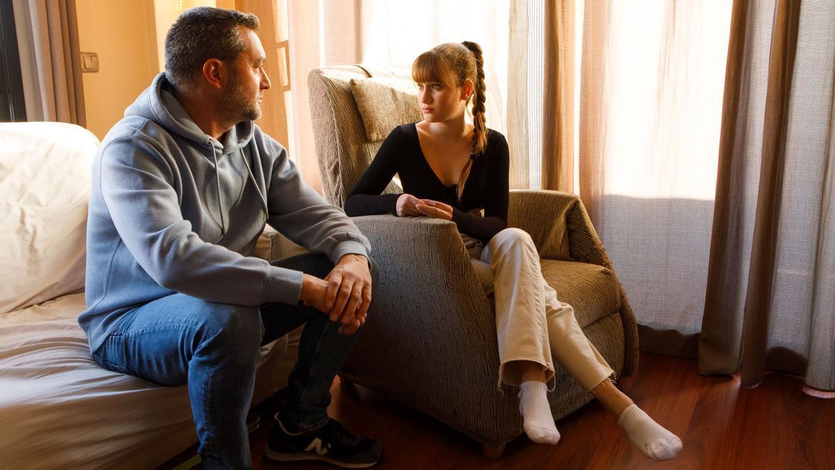David Cruz, con su hija Norah, en el salón de su casa.