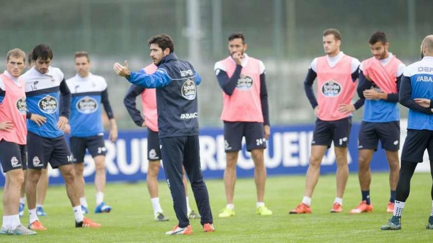 Víctor Sánchez da instrucciones sobre el césped de Abegondo en presencia de varios futbolistas.