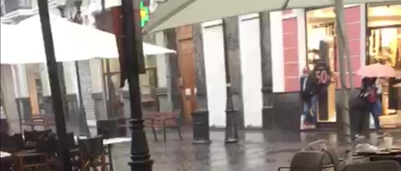 La lluvia sorprende a los primeros compradores del Black Friday en Triana