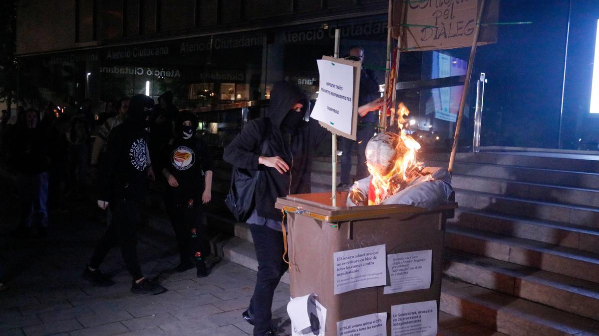 Els manifestants cremant el contenidor pel diàleg amb un ninot que representava el president Aragonès