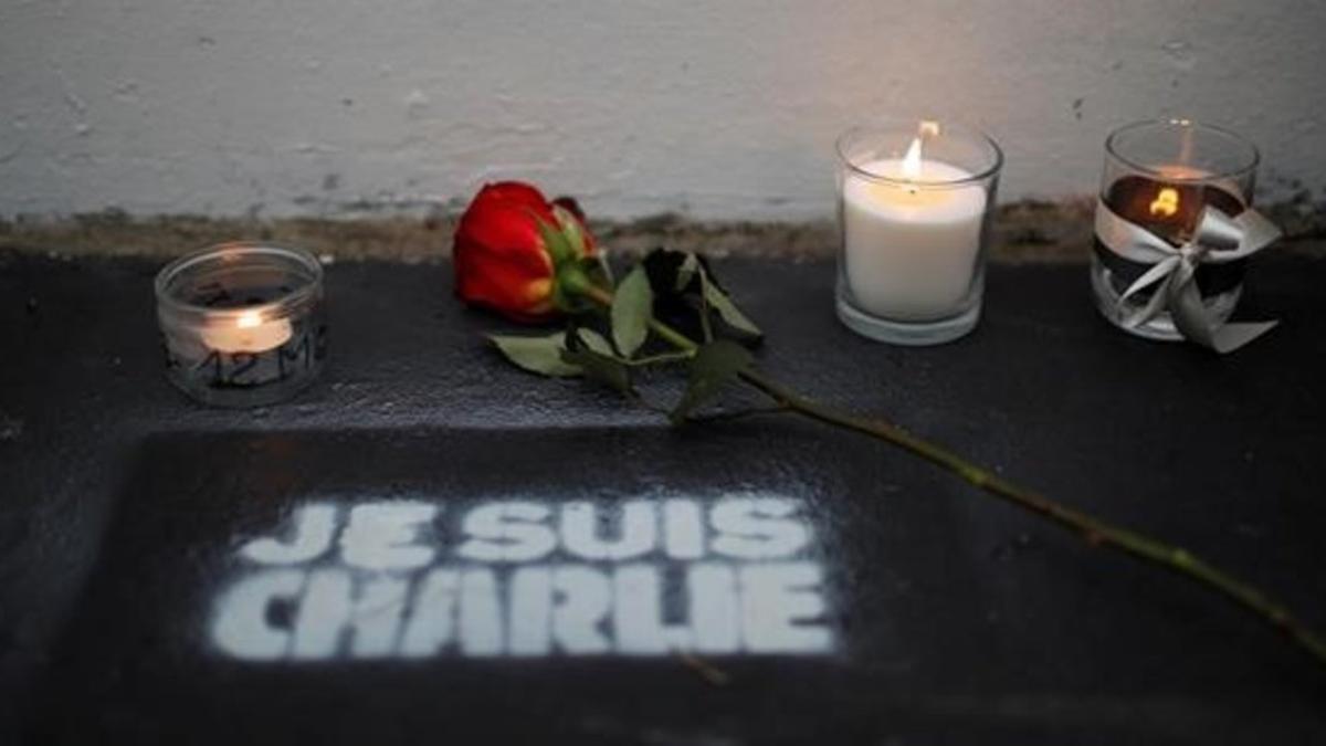 Flores y velas ante la antigua redacción de Charlie Hebdo en el quinto aniversario de la matanza.