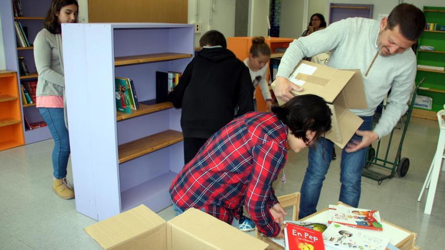 Els alumnes omplint els prestatges de la biblioteca amb els nous llibres