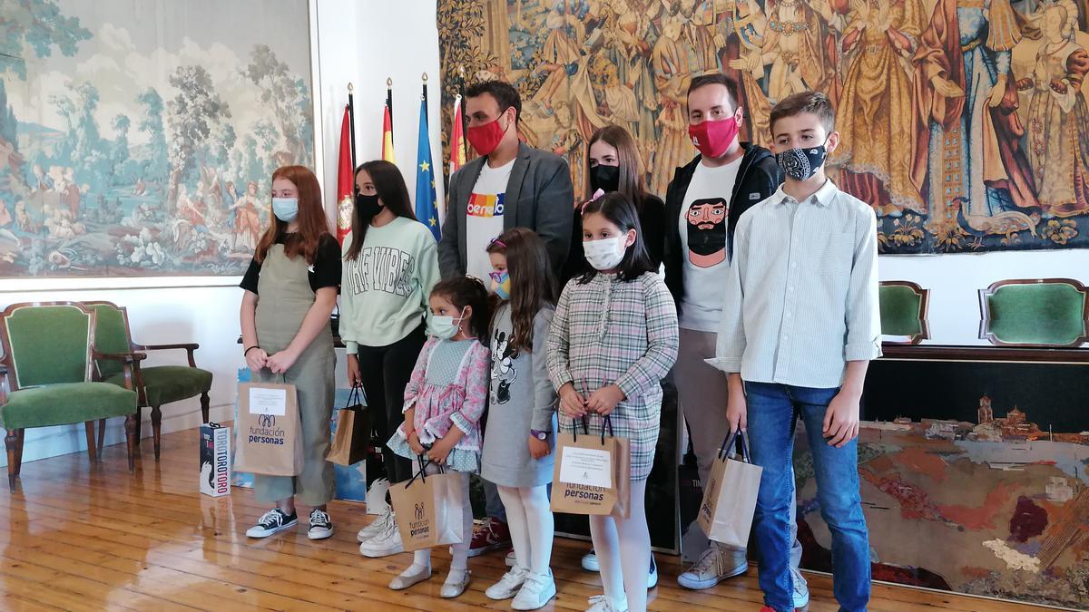 El alcalde y el concejal de Cultura posan con los niños ganadores de los concursos de dibujo y literario