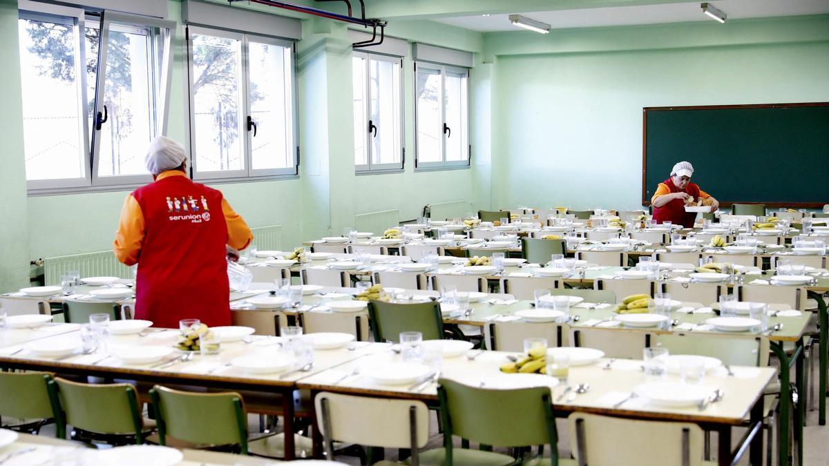 Personal prepara las mesas de un comedor escolar de Gijón.