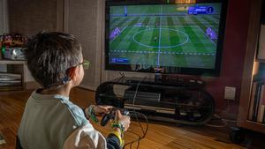 Un niño juega a un videojuego en su casa de Barcelona.
