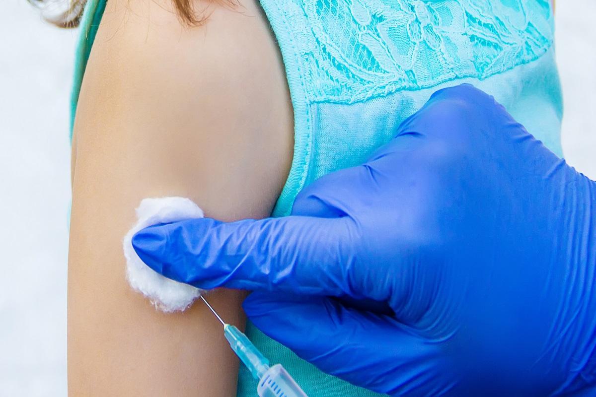 Una enfermera vacunando a un niño.