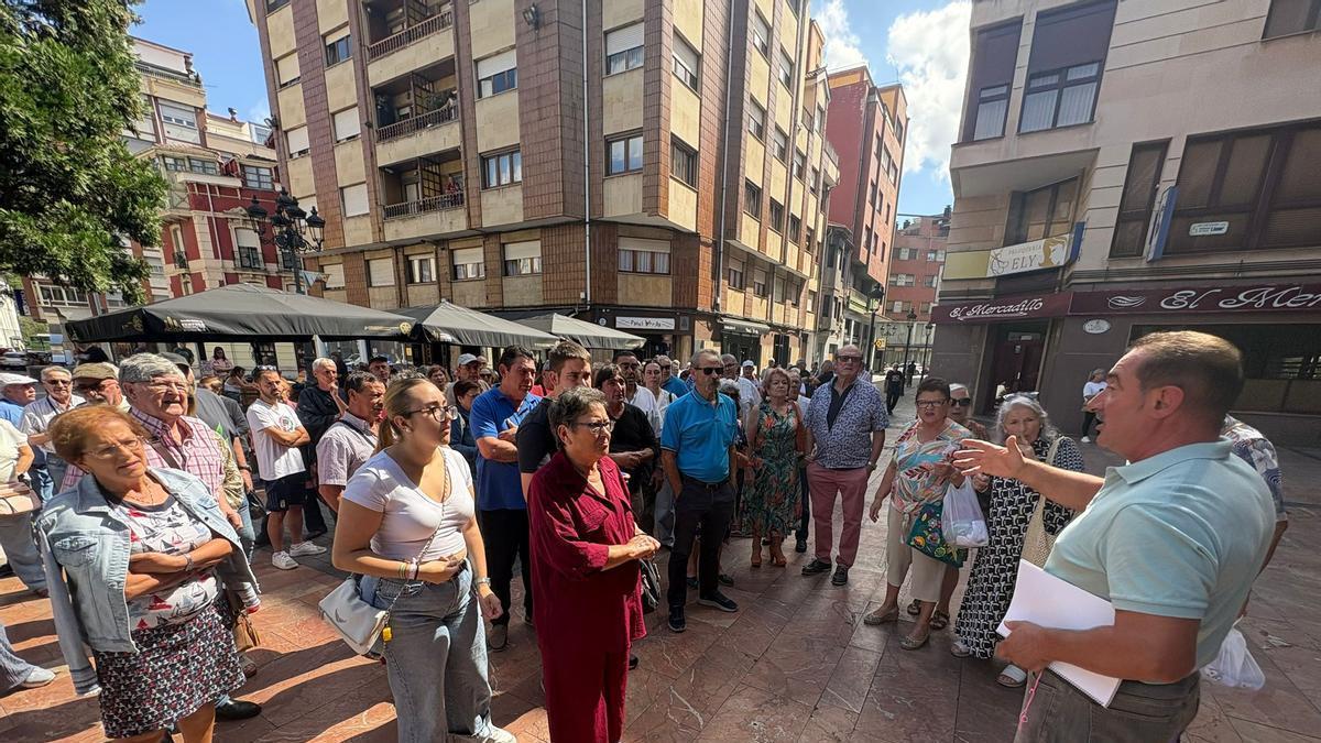 Julio González, a la derecha, se dirige a los vecinos de El Carbayu en la plaza del Ayuntamiento de Langreo