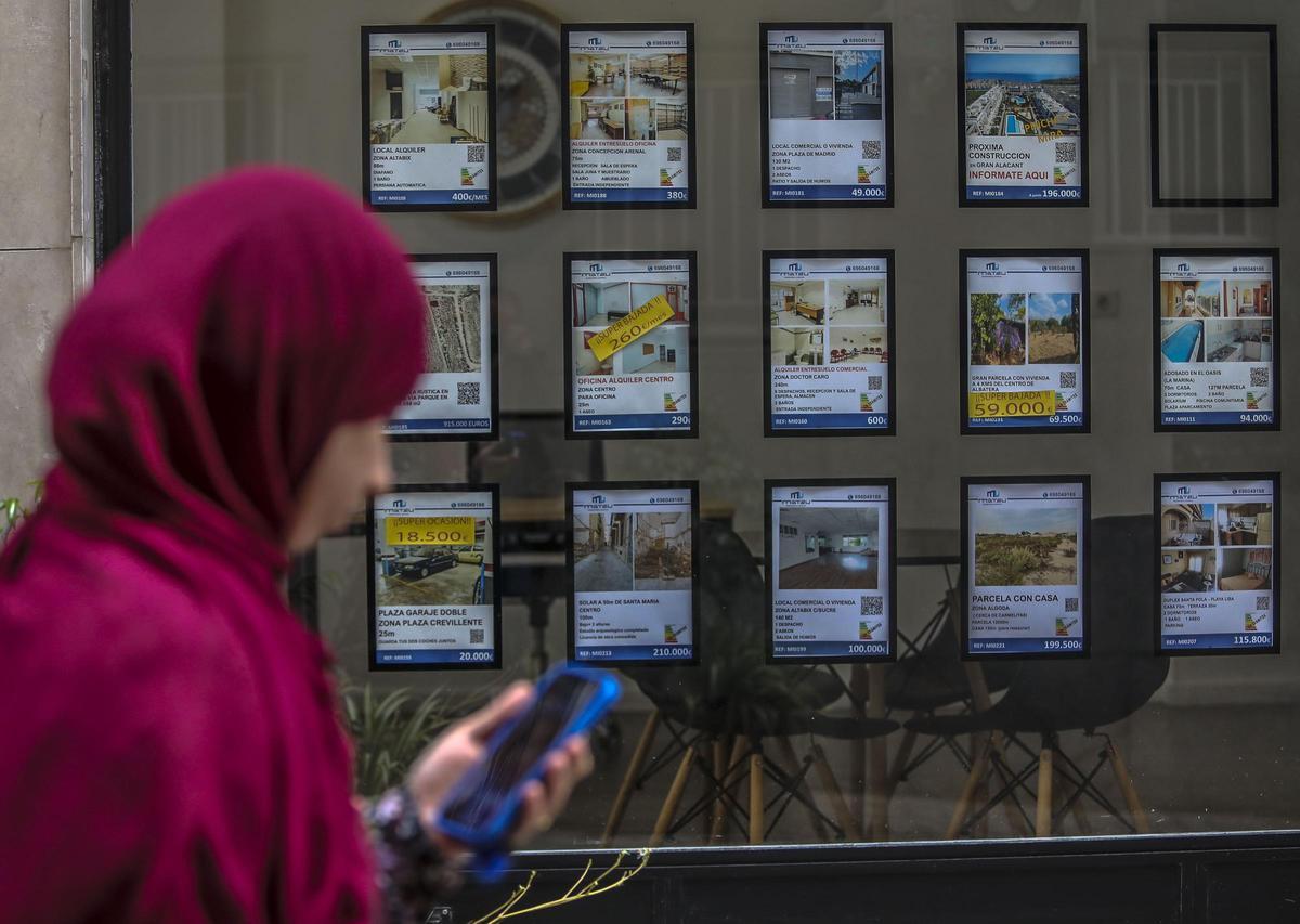 Anuncios de viviendas en el escaparate de una inmobiliaria de Elche.