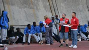 Trabajadores de Cruz Roja junto a los migrantes que han llegado esta mañana, en el muelle de la Restinga, a 11 de septiembre de 2023, en El Hierro, Canarias (España). En la mañana de hoy se ha procedido al traslado de más de 400 inmigrantes que llegaron a