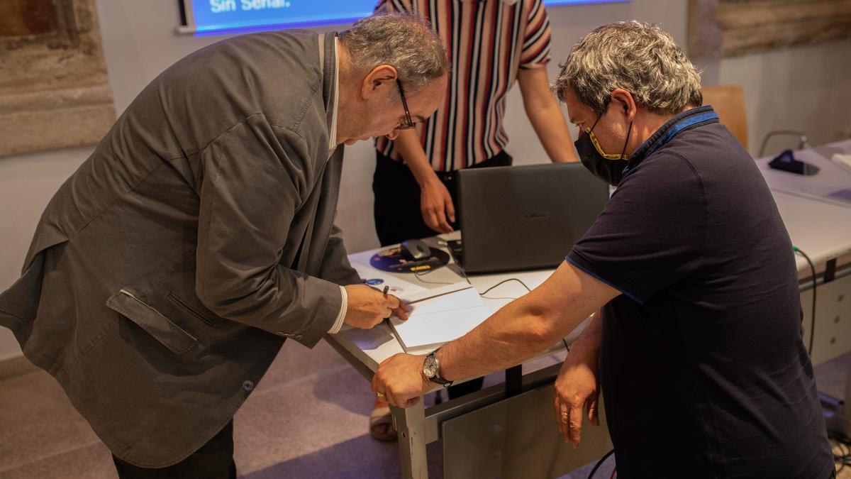 Charles García firma su libro al concluir la presentación en la Biblioteca Pública del Estado