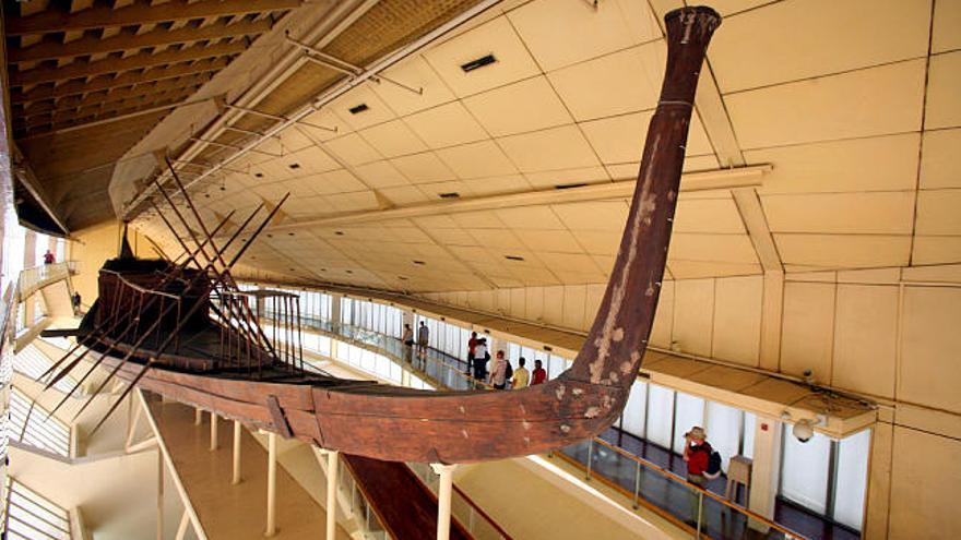 Varios turistas observan la primera barca solar de Keops durante su visita al Museo de la Barca Solar en la explanada de las pirámides en Giza (Egipto) hoy sábado 19 de julio. Los turistas pueden ver una segunda barca por una pantalla de televisión situada en este museo. La pantalla mostrará escenas del segundo barco en directo por primera vez desde que este navío fue descubierto en 1957.